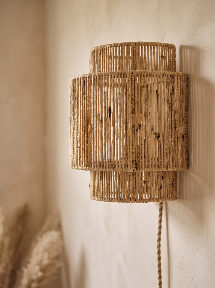 Close view of the RattanGlow Handwoven Wall Lamp weave on a limewash wall
